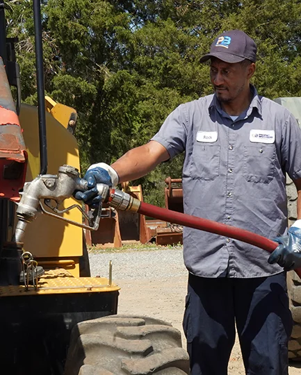 Propst Brothers worker, Rock Roseman, fueling construction equipment with a diesel hose at a jobsite.